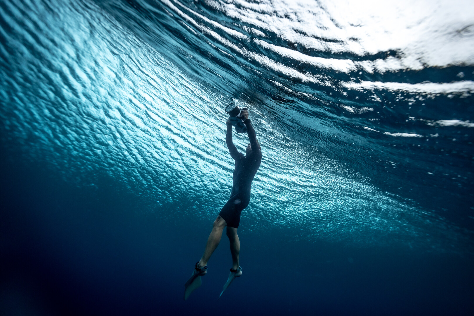 an underwater cameraman with swim fins